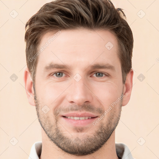 Joyful white young-adult male with short  brown hair and grey eyes