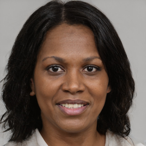 Joyful black adult female with medium  brown hair and brown eyes