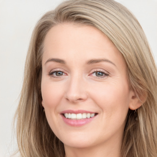 Joyful white young-adult female with long  brown hair and grey eyes