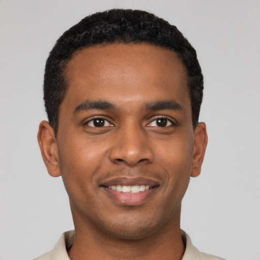 Joyful black young-adult male with short  black hair and brown eyes