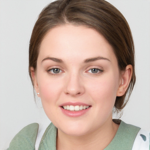 Joyful white young-adult female with medium  brown hair and green eyes