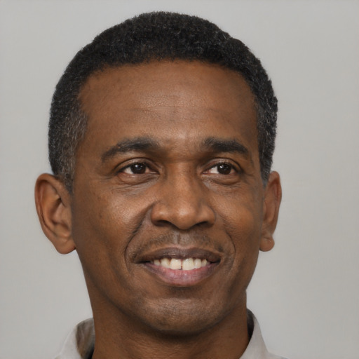 Joyful black adult male with short  black hair and brown eyes