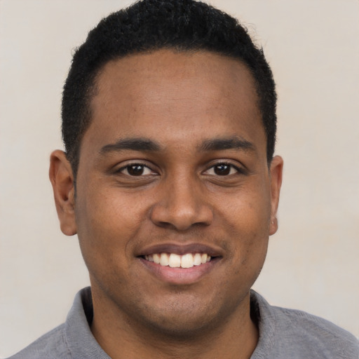 Joyful black young-adult male with short  black hair and brown eyes