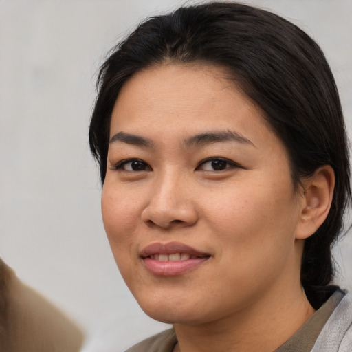 Joyful asian young-adult female with medium  brown hair and brown eyes