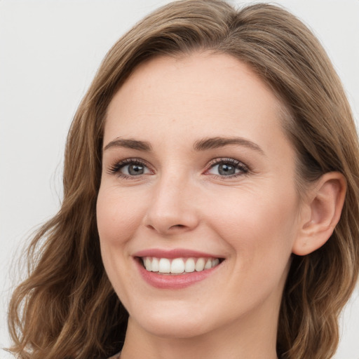 Joyful white young-adult female with long  brown hair and green eyes