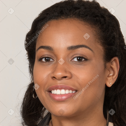 Joyful black young-adult female with long  brown hair and brown eyes