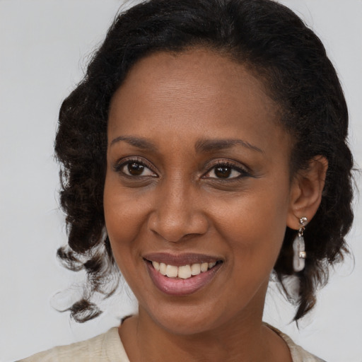 Joyful black young-adult female with medium  brown hair and brown eyes