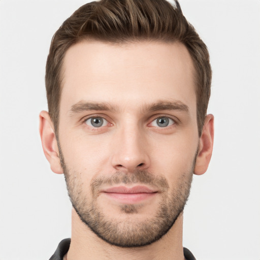 Joyful white young-adult male with short  brown hair and grey eyes