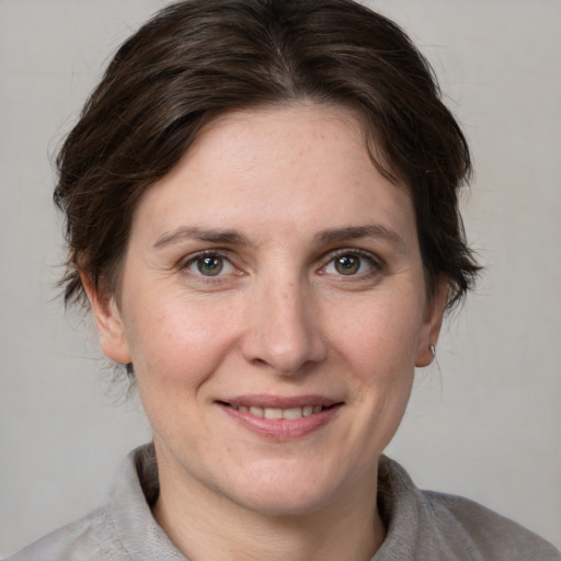 Joyful white adult female with medium  brown hair and grey eyes