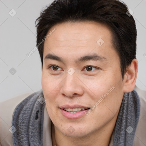 Joyful asian young-adult male with short  brown hair and brown eyes