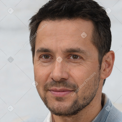 Joyful white adult male with short  brown hair and brown eyes