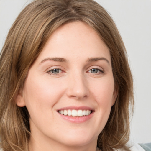 Joyful white young-adult female with medium  brown hair and green eyes