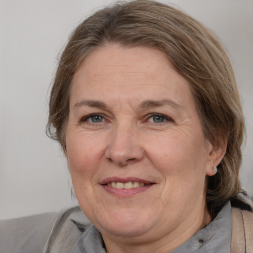 Joyful white adult female with medium  brown hair and grey eyes