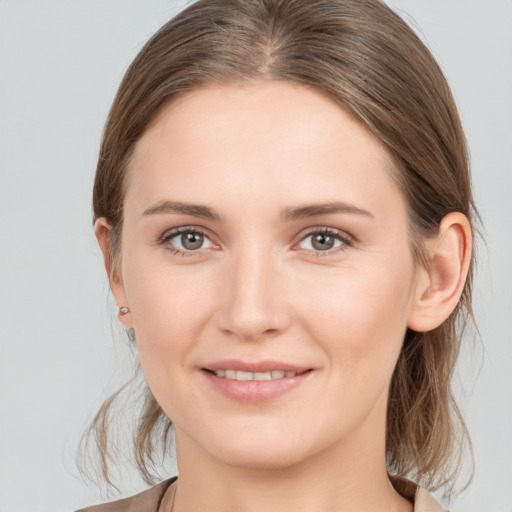 Joyful white young-adult female with medium  brown hair and grey eyes