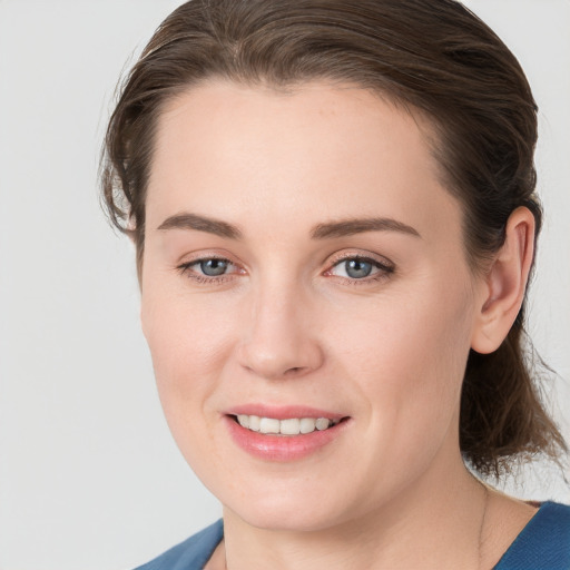 Joyful white young-adult female with medium  brown hair and grey eyes