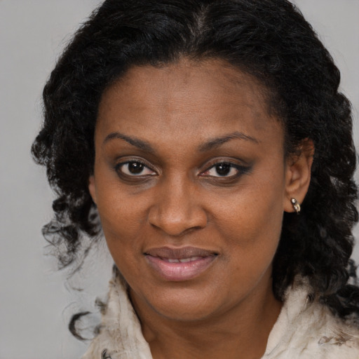 Joyful black adult female with long  brown hair and brown eyes