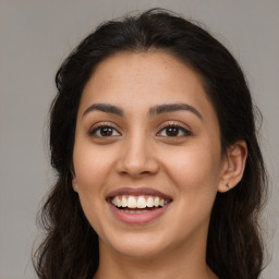 Joyful latino young-adult female with long  brown hair and brown eyes