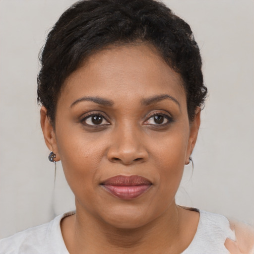 Joyful black young-adult female with short  brown hair and brown eyes