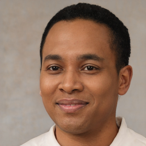 Joyful black young-adult male with short  black hair and brown eyes