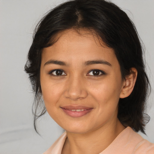 Joyful latino young-adult female with medium  brown hair and brown eyes