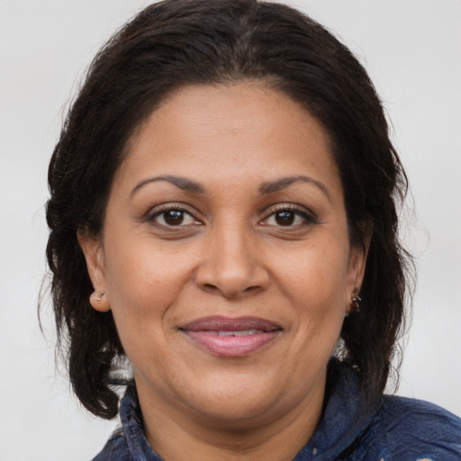 Joyful latino adult female with medium  brown hair and brown eyes