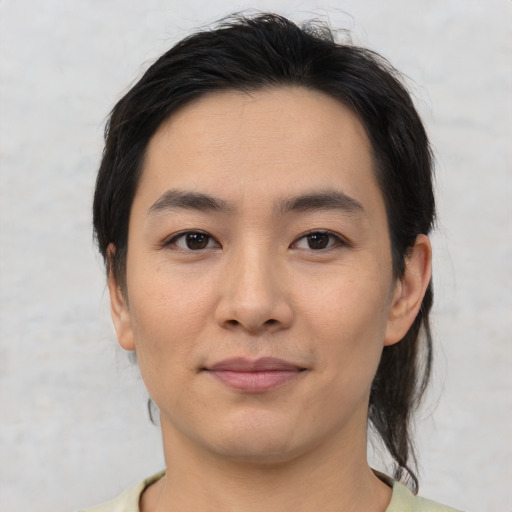 Joyful asian young-adult male with medium  black hair and brown eyes