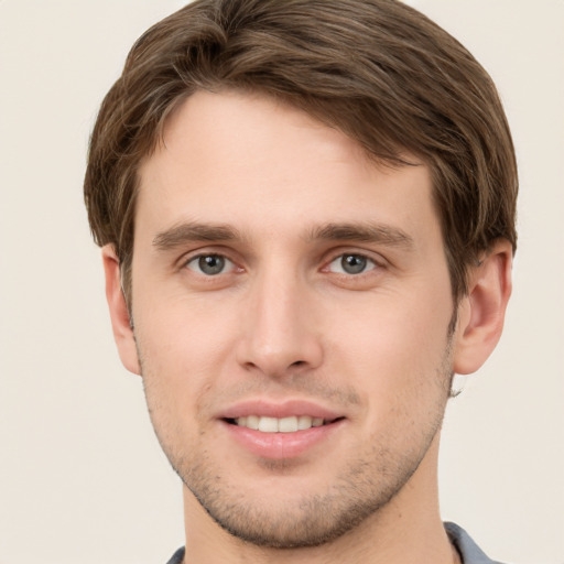 Joyful white young-adult male with short  brown hair and grey eyes