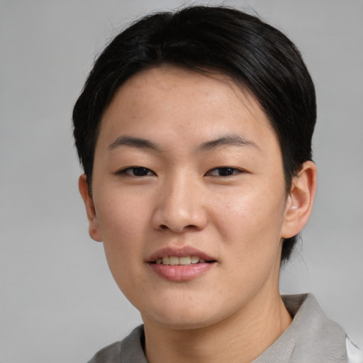 Joyful asian young-adult female with short  black hair and brown eyes