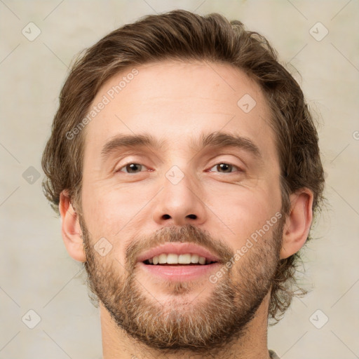 Joyful white young-adult male with short  brown hair and grey eyes