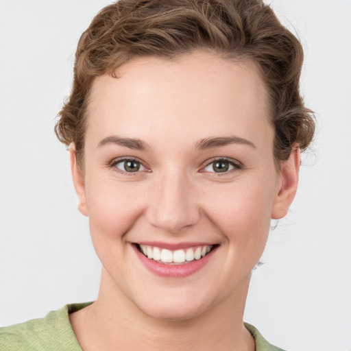 Joyful white young-adult female with short  brown hair and green eyes