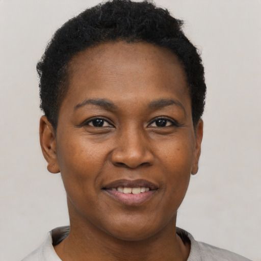 Joyful black young-adult female with short  black hair and brown eyes