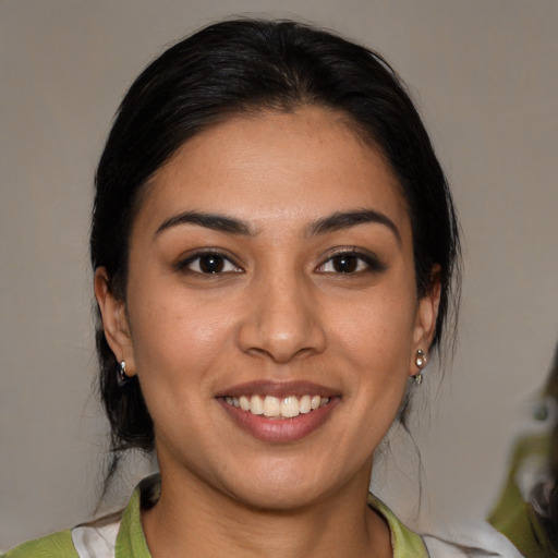 Joyful latino young-adult female with medium  brown hair and brown eyes