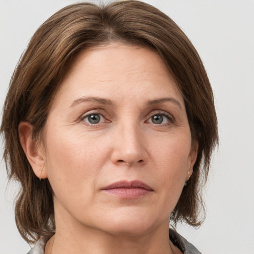 Joyful white adult female with medium  brown hair and grey eyes