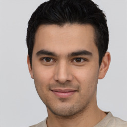 Joyful latino young-adult male with short  black hair and brown eyes