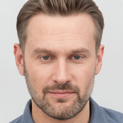 Joyful white adult male with short  brown hair and grey eyes