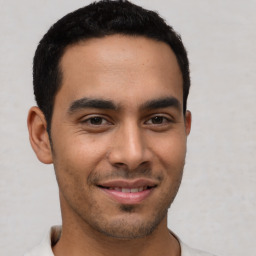 Joyful latino young-adult male with short  brown hair and brown eyes