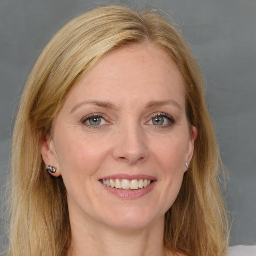 Joyful white adult female with long  brown hair and blue eyes