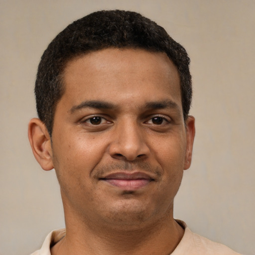 Joyful latino young-adult male with short  brown hair and brown eyes