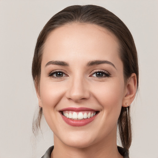 Joyful white young-adult female with medium  brown hair and grey eyes