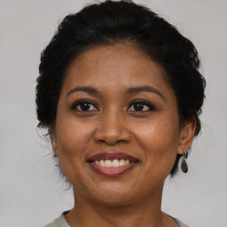 Joyful black adult female with medium  brown hair and brown eyes