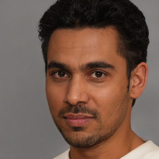 Joyful latino young-adult male with short  black hair and brown eyes
