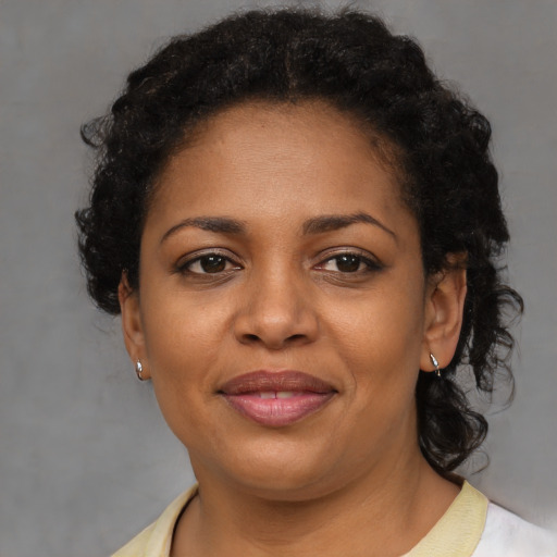 Joyful black adult female with short  brown hair and brown eyes