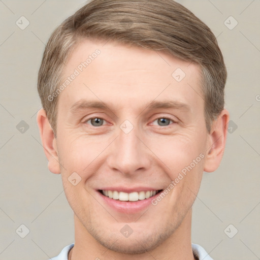 Joyful white young-adult male with short  brown hair and grey eyes