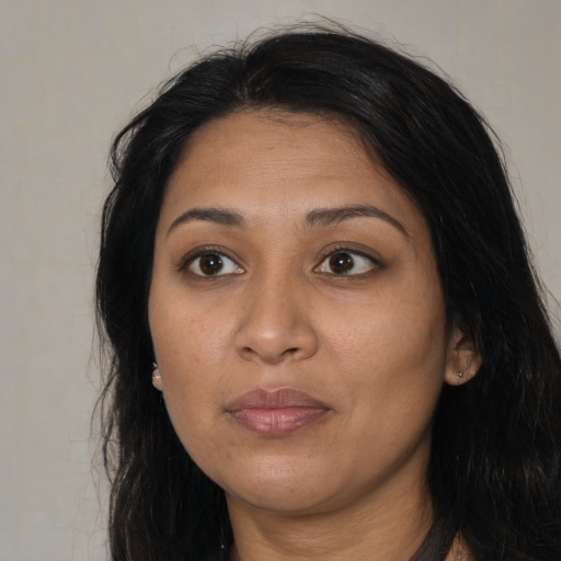 Joyful latino adult female with long  black hair and brown eyes