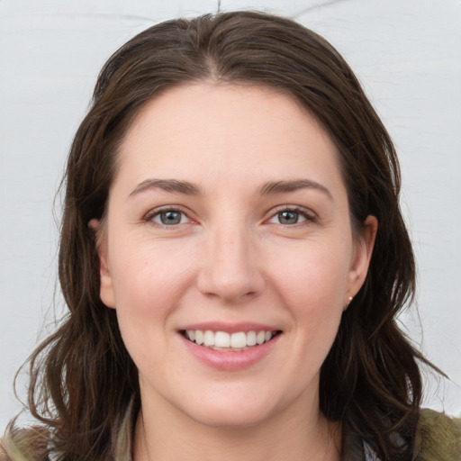 Joyful white young-adult female with medium  brown hair and grey eyes