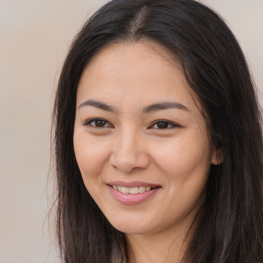 Joyful asian young-adult female with long  brown hair and brown eyes