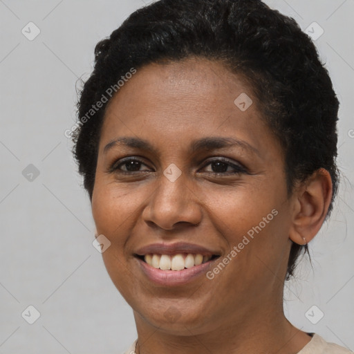 Joyful black young-adult female with short  brown hair and brown eyes