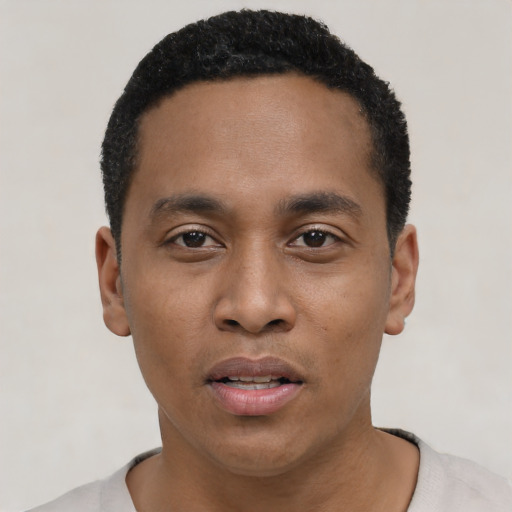 Joyful black young-adult male with short  black hair and brown eyes