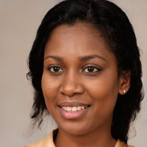Joyful black young-adult female with medium  brown hair and brown eyes