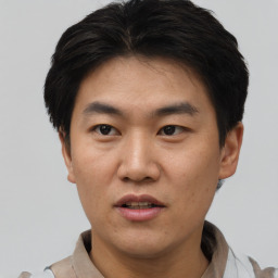 Joyful asian adult male with short  black hair and brown eyes